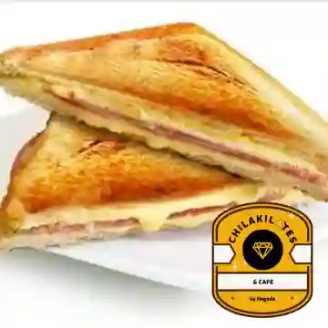 Sándwich planchado con jamón de pavo, queso gouda y aguacate, acompañado de papas